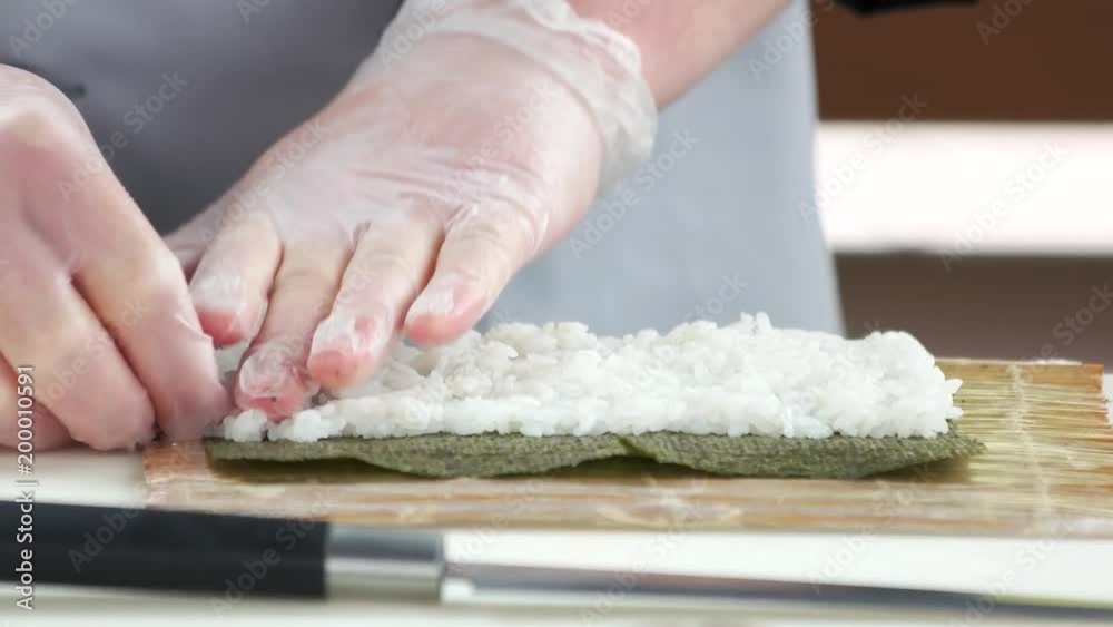 Hands preparing sushi close up. Rice and nori. Hands preparing sushi close up. Rice and nori.