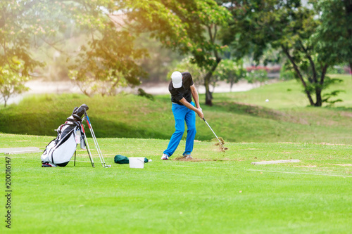 Man hitting golf ball on a golf course while on summer vacation.