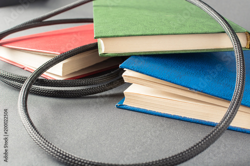 Colorful books wrapped in black wire