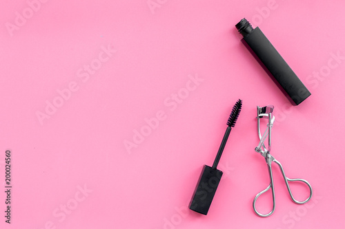 Fototapeta Naklejka Na Ścianę i Meble -  Basic products for eyelashes makeup. Mascara and eyelash curler on pink background top view copy space