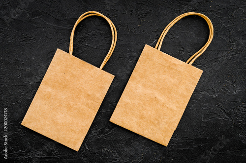 Brown kraft paper bag for shopping on black background top view mockup