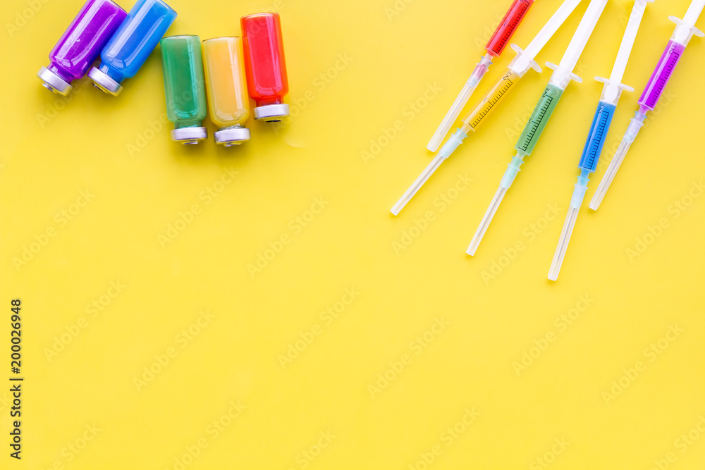 Medical injection Syringe and bottle with remedy on yellow background top view copy space Medical injection Syringe and bottle with remedy on yellow background top view copy space