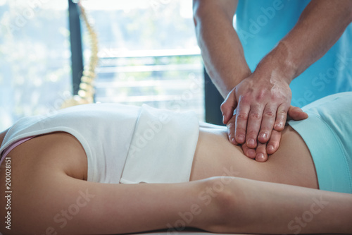 Male physiotherapist giving back massage to female patient