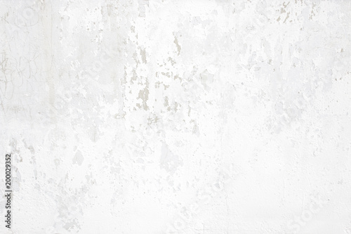 White concrete wall with small cracks and shabby plaster on surface