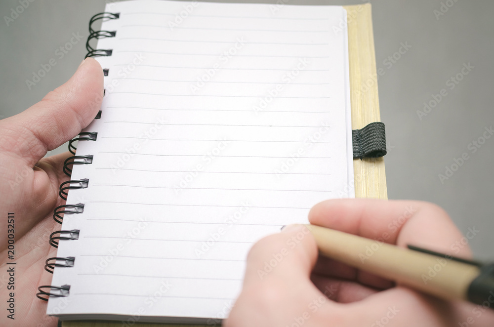 Businessman holds in hand a note pad with pen. To do list template. Goals or business tricks. Business tips concept. Task Manager.concept. Special offer.. Businessman holds in hand a note pad with pen. To do list template. Goals or business tricks. Business tips concept. Task Manager.concept. Special offer..