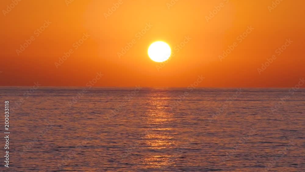 Timelapse of golden sun setting over calm ocean waters Timelapse of golden sun setting over calm ocean waters