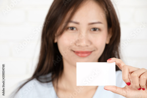 Asian woman smiling holding the card.