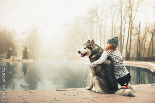 Tableau sur toile Image of young girl with her dog, alaskan malamute, outdoor
