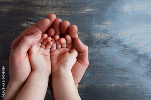 Two pairs of empty hands Adult and Children on a dark wooden background.