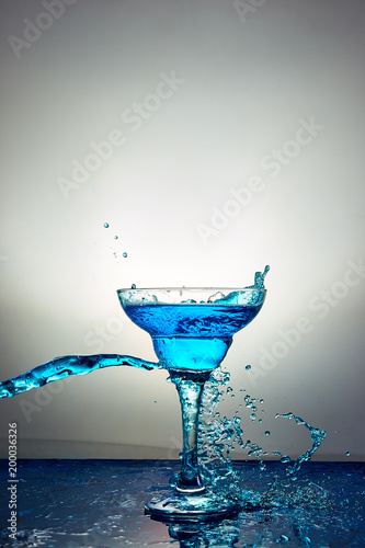 Glass with blue champagne or cocktail. Levitation