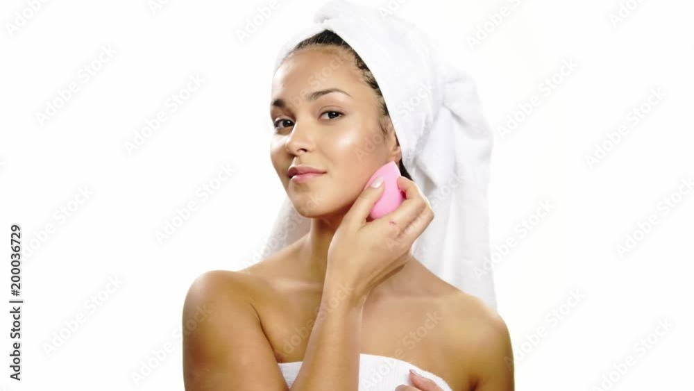 Woman using special sponge on her face. Woman using special sponge on her face.