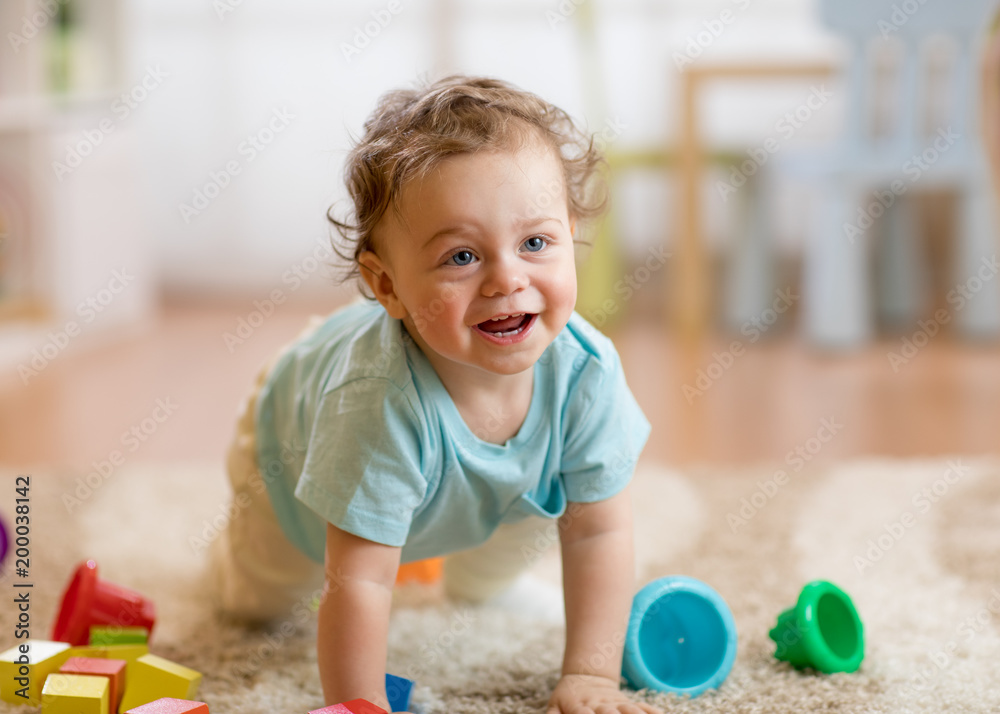 Happy baby boy playing and crawling on the floor at home Happy baby boy playing and crawling on the floor at home