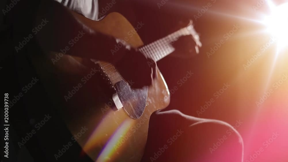 Guitarist playing acoustic guitar. Unplugged performance in the dark.