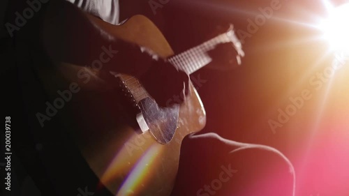 Guitarist playing acoustic guitar. Unplugged performance in the dark.