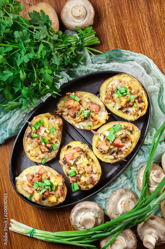 Baked potatoes in jacket stuffed with bacon, mushrooms and chees