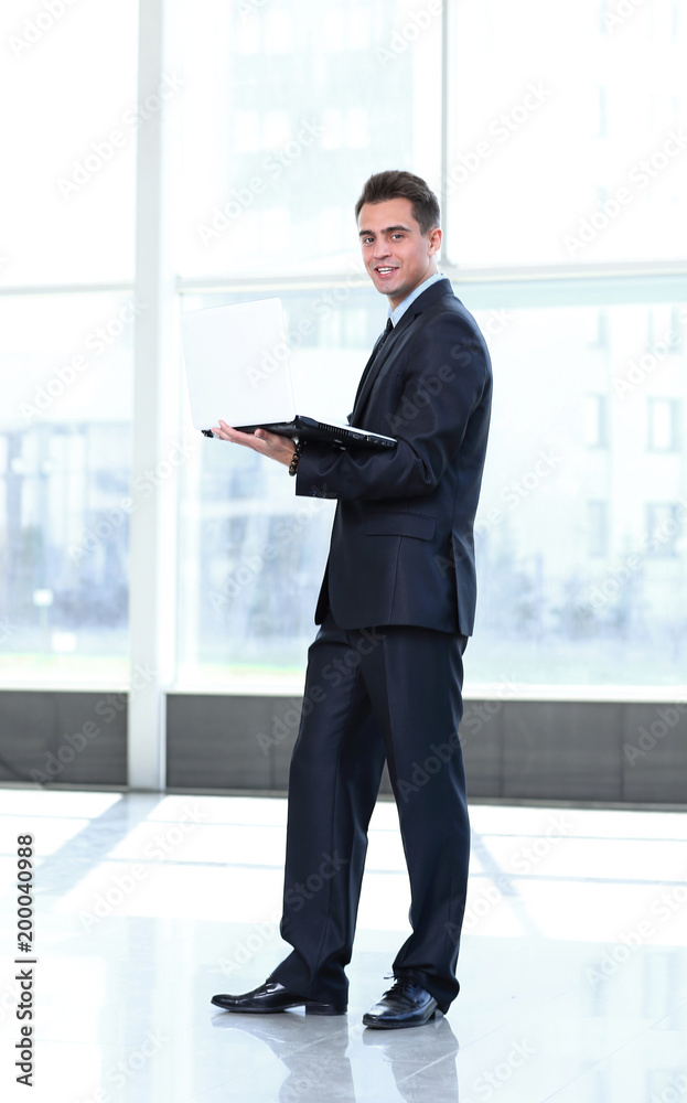 Male business executive using laptop in office