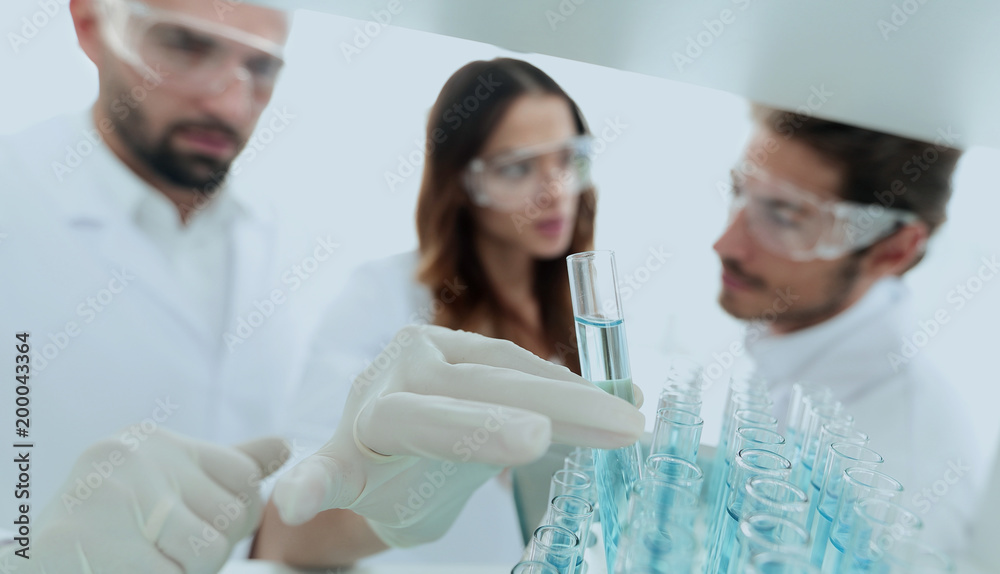 Fototapeta premium background image is a group of scientists studying the liquid in the glass tube.