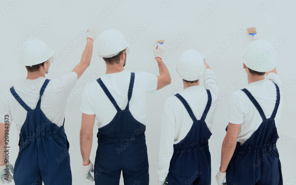 rear view.construction workers paint the wall. rear view.construction workers paint the wall.