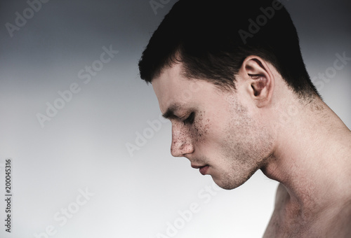 Foto Side view sad man having many freckles on face