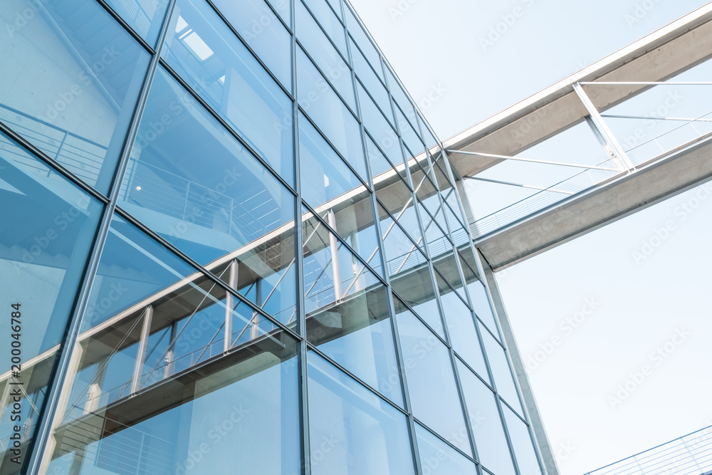 Glass facade and reflection, modern architecture building exterior and blue sky Glass facade and reflection, modern architecture building exterior and blue sky