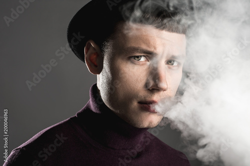 Portrait of depressed man fuming cigar. He isolated on dark background. Doldrum and rest concept