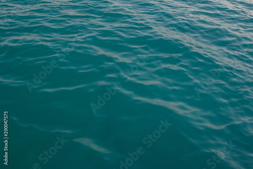 Surface of water with waves background texture, clear blue water in a red sea with a wave, dark blue sea wave close up, green water, glare of light on the water