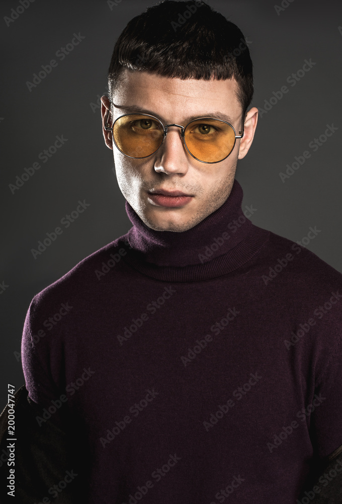 Portrait of orderly man wearing modern glasses while isolated on black background. Style and tranquility concept