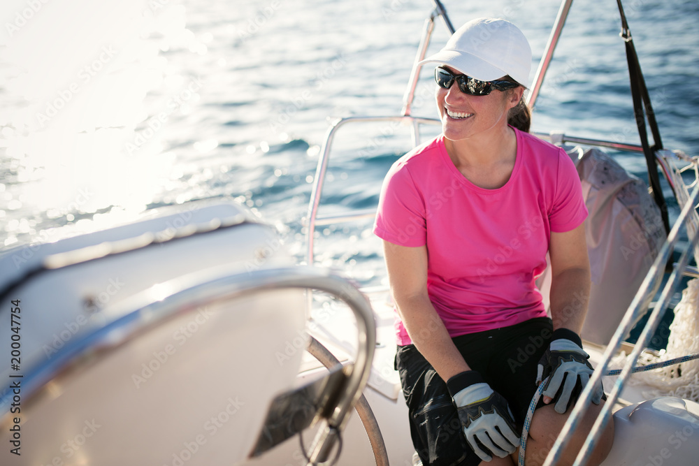 Happy strong woman sailing with her boat