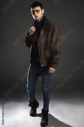 Fényképezés Full length portrait of concentrated brutal man keeping collar of sweater
