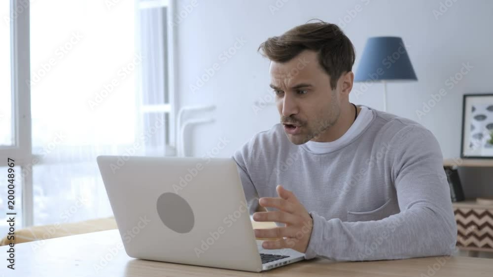 Upset Angry Adult Man Yelling while Working on Laptop Upset Angry Adult Man Yelling while Working on Laptop