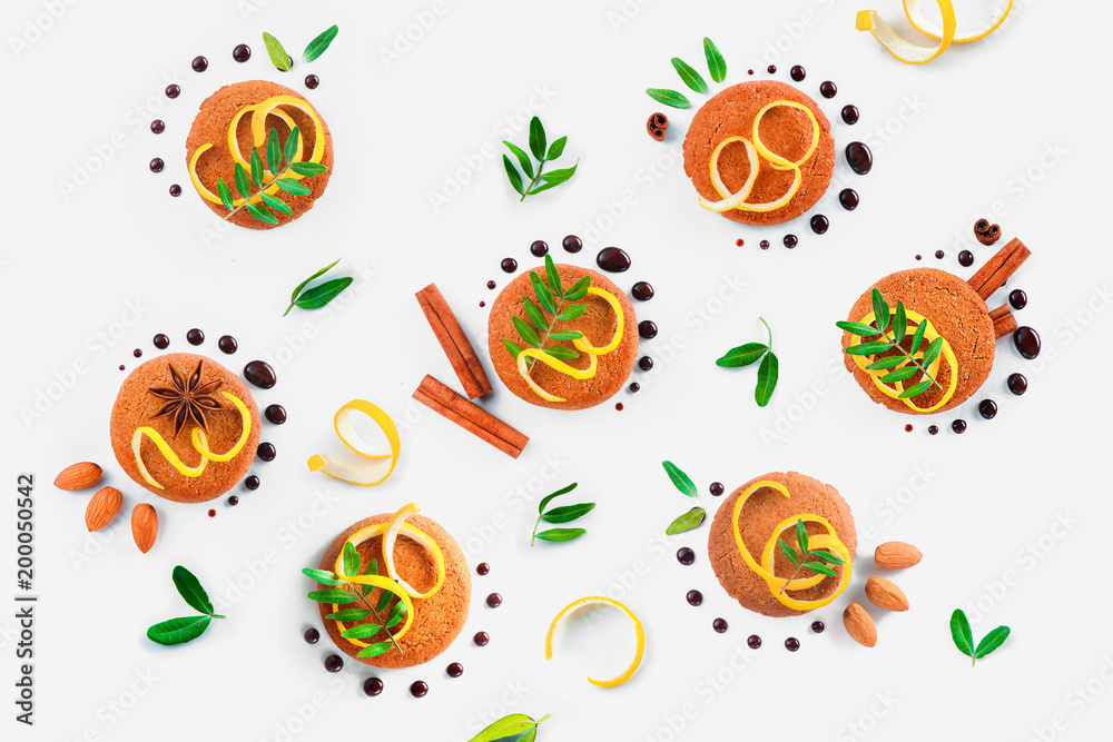 Food styling tips pattern made of cookies, chocolate swooshes and rings, cinnamon, lemon zest and green leaves. Cookie decoration concept