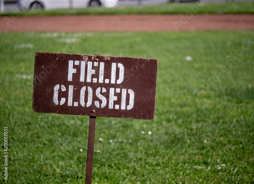 “Field closed” sign blocking access to a field in a park