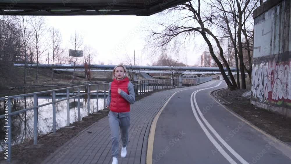 Fit woman jogging in city in beautiful sunrise Fit woman jogging in city in beautiful sunrise