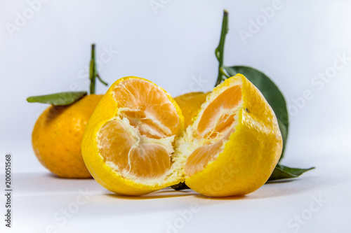 Two separate portions of fresh fruit, fresh tangerine, white background.
