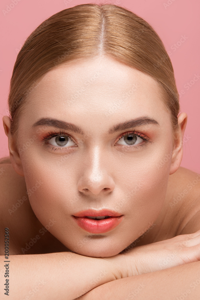 Close up portrait of well cared woman with natural maquillage staring at camera with dreaminess. Isolated on rose background Close up portrait of well cared woman with natural maquillage staring at camera with dreaminess. Isolated on rose background