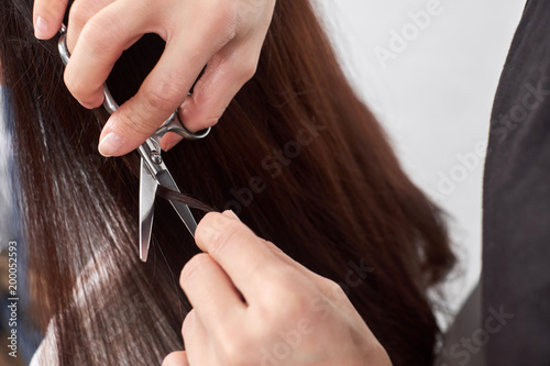 Close-up of a hair stylist cutting the hair of a woman.