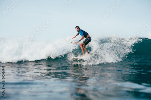 handsome young man in wetsuit surfing on sunny day © LIGHTFIELD STUDIOS