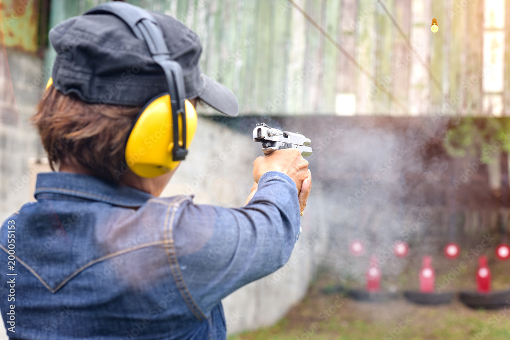 shot gun magazine in hand of old woman is reflect in flicking after shooting bullet away to the target, effective against weight of gun recoil spring works after shooting by stable action shot gun magazine in hand of old woman is reflect in flicking after shooting bullet away to the target, effective against weight of gun recoil spring works after shooting by stable action