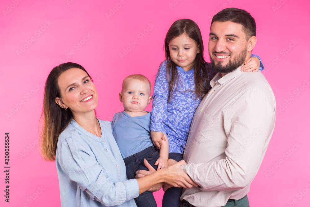 Happy mixed race family portrait smiling on pink background