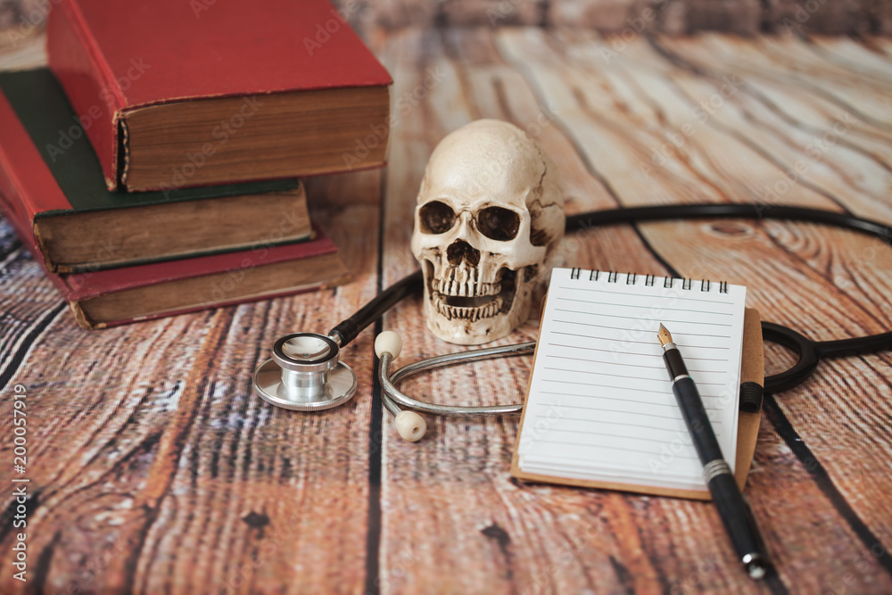 skull with old text book ,concept with medical education . skull with old text book ,concept with medical education .