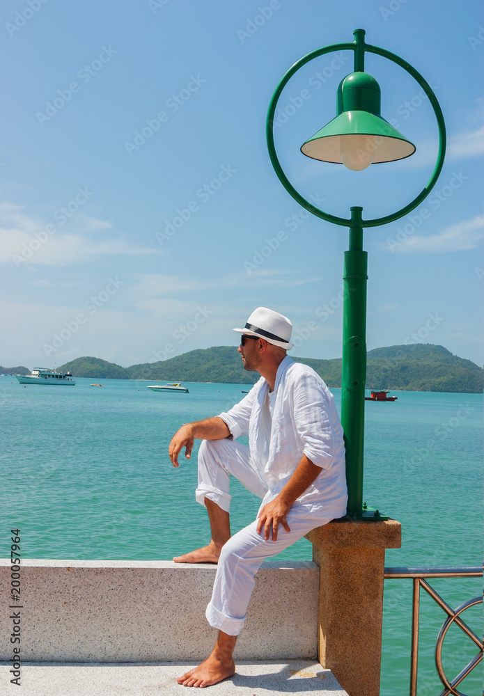 A young man sits on the waterfront