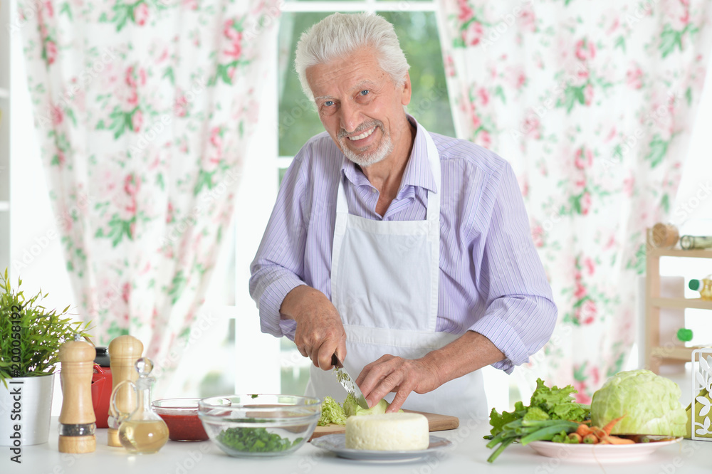 Fototapeta premium Senior man preparing dinner in kitchen