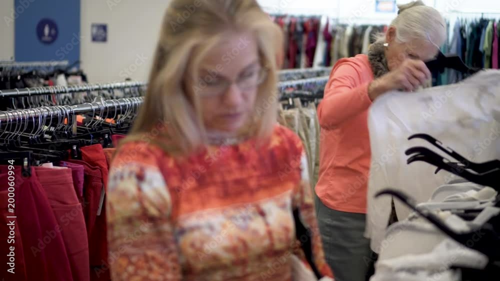 custom made wallpaper toronto digitalCloseup and focus shift of two pretty blond women looking at clothes in a second hand clothing store.
