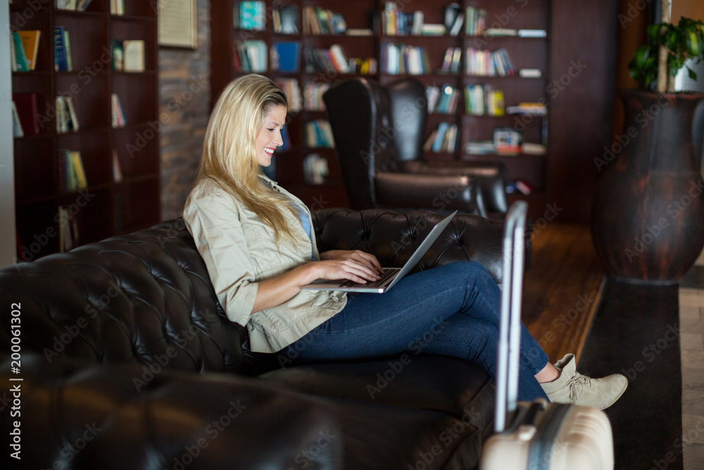 Woman using laptop in waiting area Woman using laptop in waiting area
