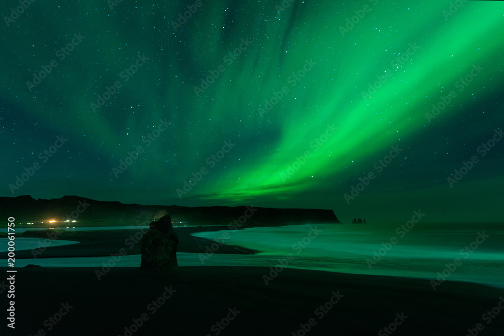 The Northern Light at the Vik Cliffs Iceland. Landscape of Vik beach; with green bands of Aurora Borealis. Night Seascape a paradise for travel and vacations.