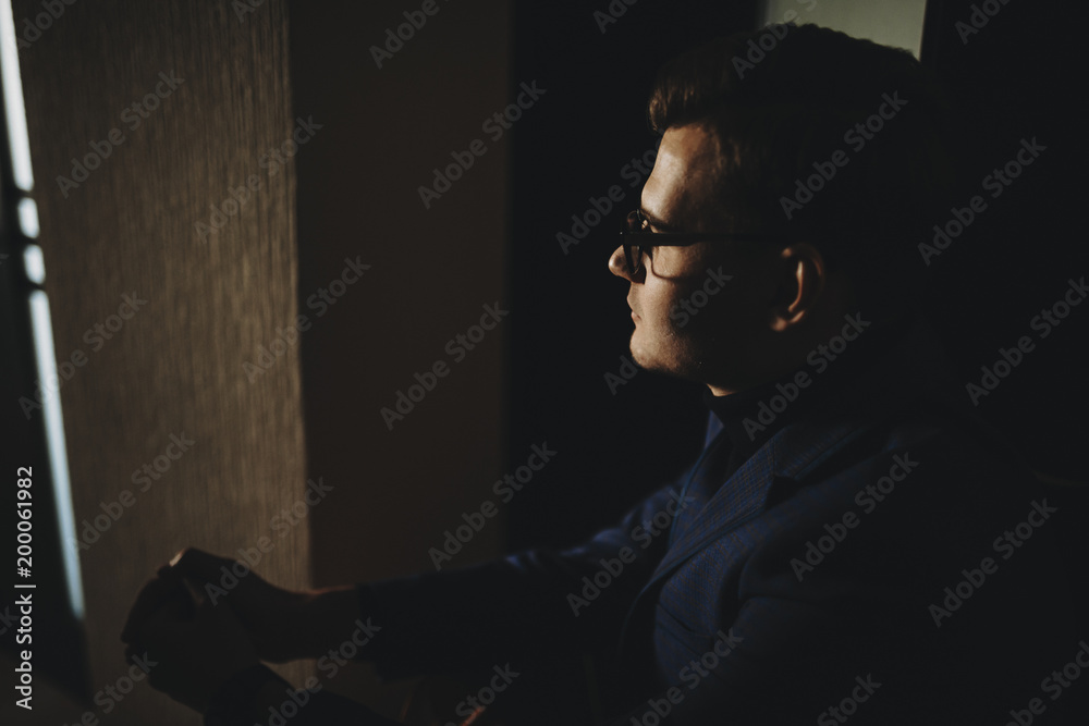 Handsome freelancer sitting at home in the morning looking at the sunrise through the window. Handsome freelancer sitting at home in the morning looking at the sunrise through the window.
