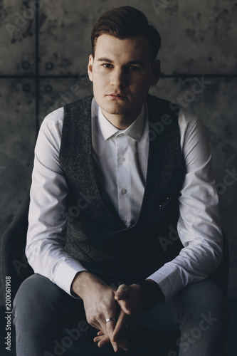 Handsome businessman sitting in the chair and looking at camera. Portrait of successful businessman.