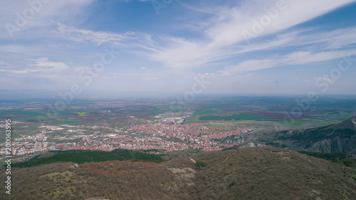 Aerial View Of High Attitude Mountains With Small Road And Town In The Background