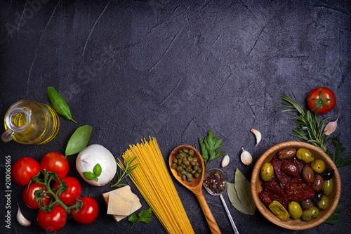 Selection of healthy food. Italian food background with spaghetti, cheese, olives, tomatoes and basil. Slate banner background. View from above, top, flat lay with room for text