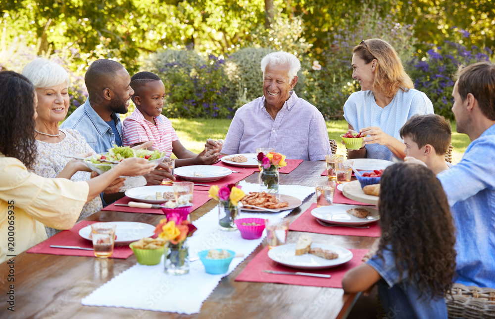 Family and friends serving lunch at a table in the garden Family and friends serving lunch at a table in the garden